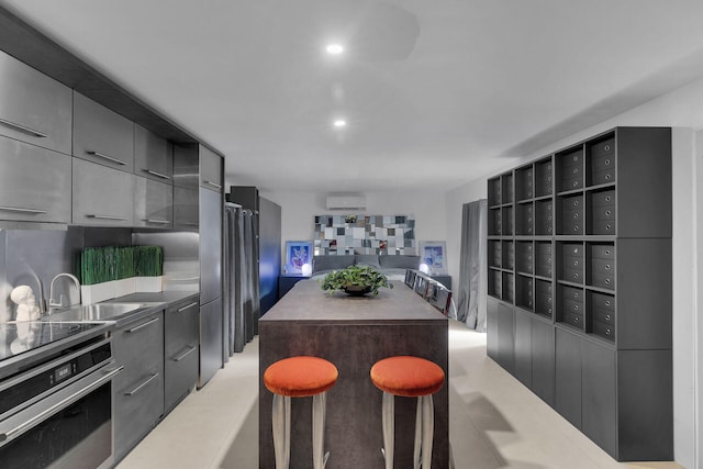 kitchen featuring mail boxes, electric range, a kitchen breakfast bar, a wall mounted air conditioner, and oven