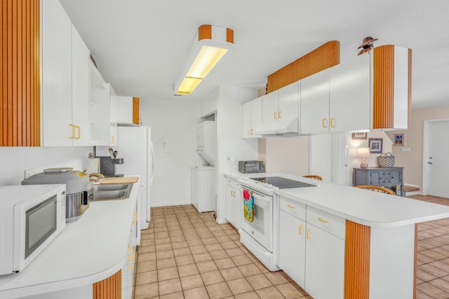 12690 Overseas Hwy Unit 52, Marathon, FL 33050 - kitchen featuring light countertops, a peninsula, white appliances, under cabinet range hood, and stacked washer and dryer