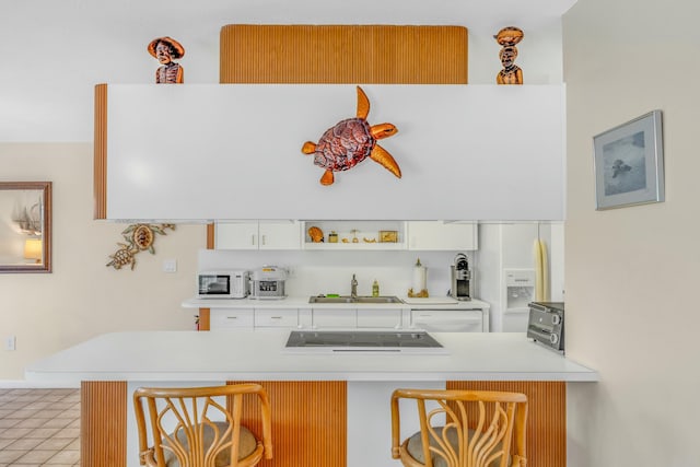 12690 Overseas Hwy Unit 52, Marathon, FL 33050 - kitchen with a kitchen bar, white cabinets, a sink, and light countertops