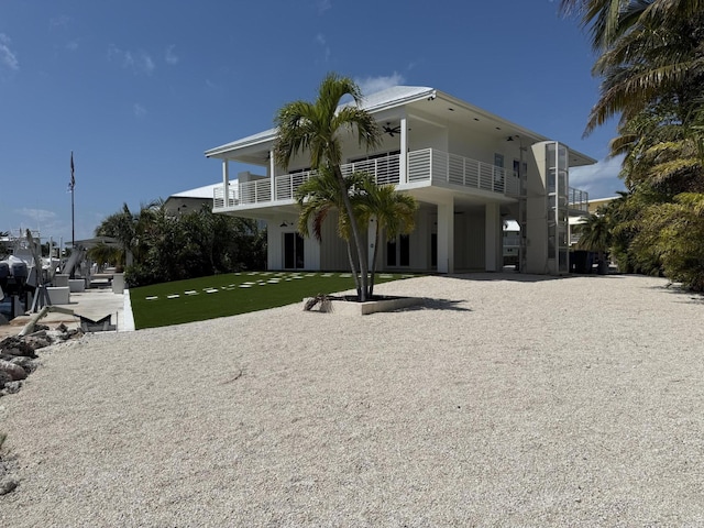 view of front of property featuring a balcony and a front yard