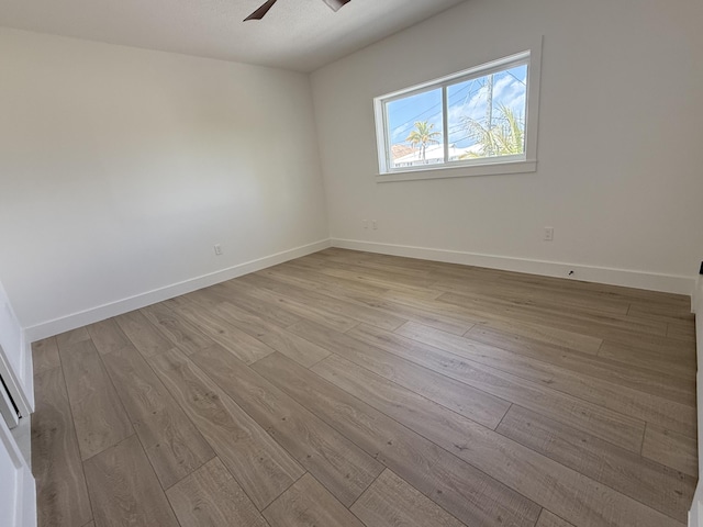 empty room with baseboards, a ceiling fan, and wood finished floors