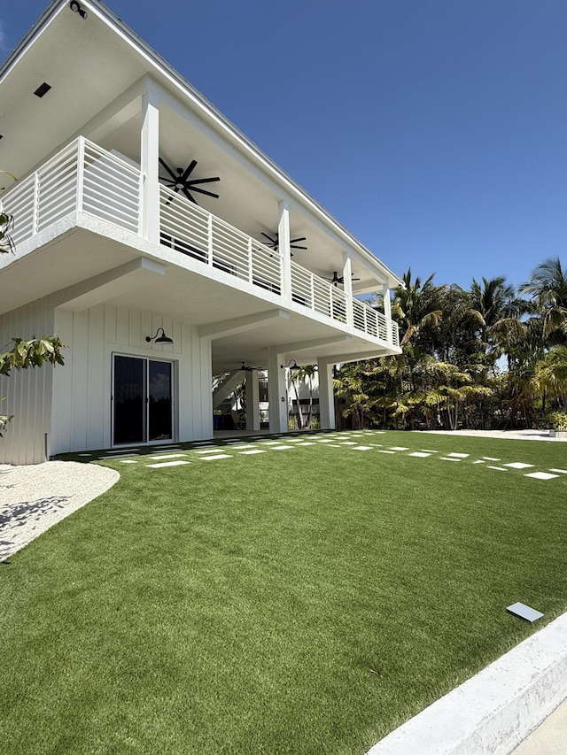 view of yard featuring a balcony and ceiling fan