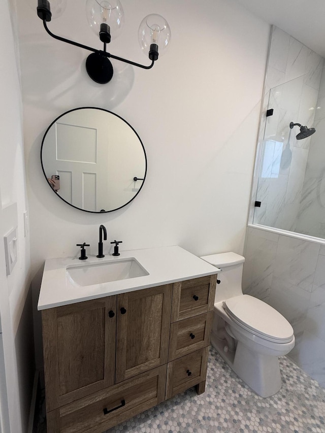 full bath with a marble finish shower, toilet, and vanity