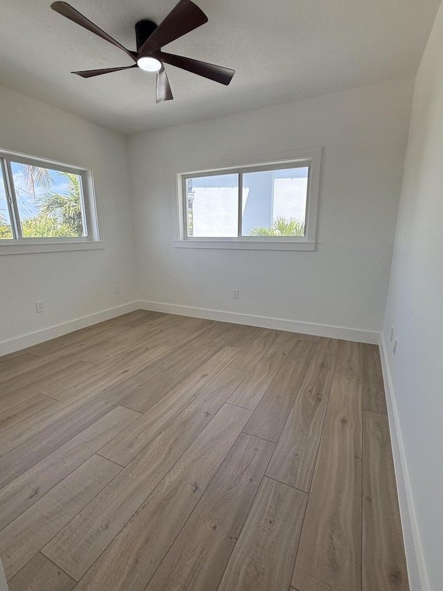 spare room with a ceiling fan, baseboards, and wood finished floors