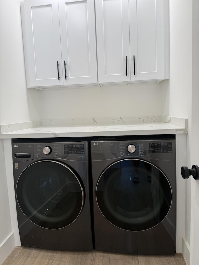 washroom with washing machine and clothes dryer and cabinet space