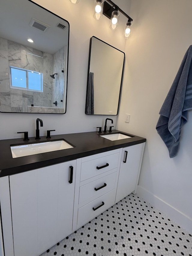 bathroom with a sink, visible vents, and a tile shower