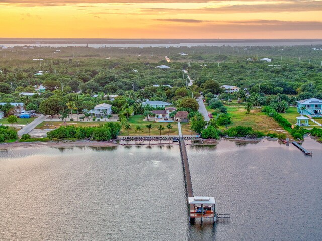 aerial view at dusk featuring a water view