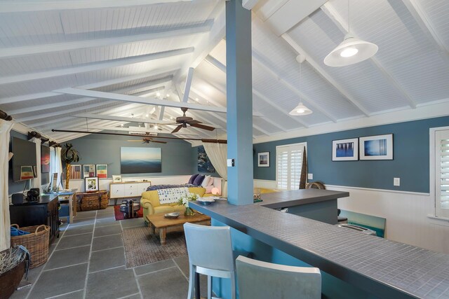 interior space with lofted ceiling with beams and ceiling fan