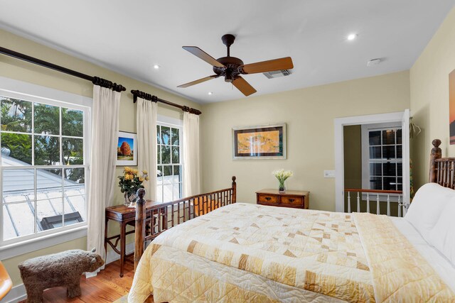 bedroom with ceiling fan, hardwood / wood-style floors, and multiple windows