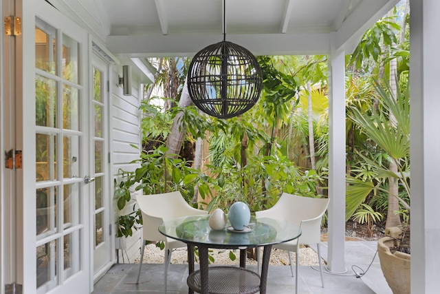 sunroom / solarium featuring beamed ceiling