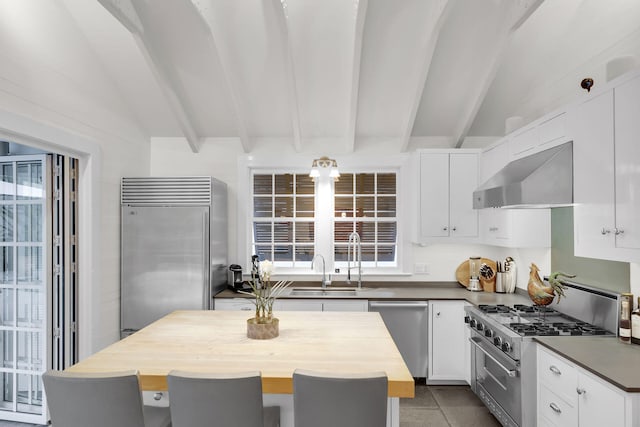 kitchen featuring white cabinetry, a center island, wall chimney range hood, and premium appliances