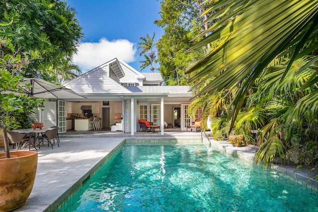 view of pool featuring an outbuilding, a patio, and french doors