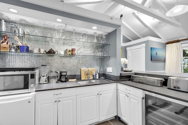 kitchen with sink, vaulted ceiling with beams, white cabinets, wine cooler, and decorative backsplash