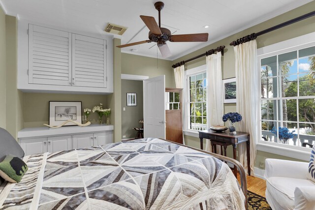 bedroom with hardwood / wood-style flooring, ornamental molding, and ceiling fan