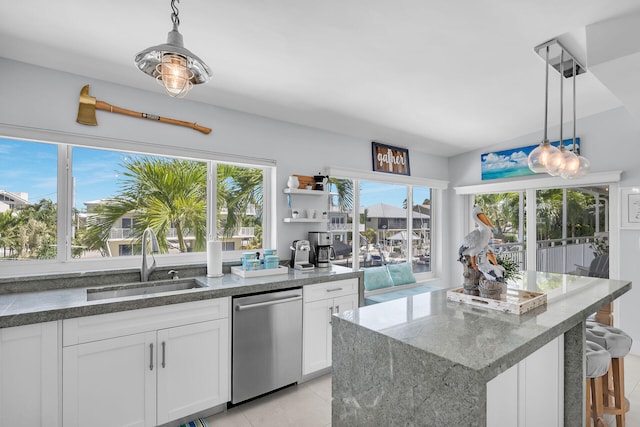 kitchen with pendant lighting, white cabinetry, dishwasher, and sink