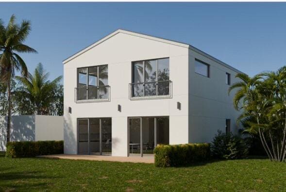 rear view of property with a yard and a patio area