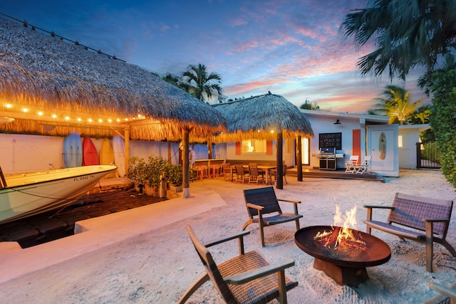 181 Ocean View Dr, Key Largo, FL 33037 - patio terrace at dusk with an outdoor fire pit, a grill, and a patio area