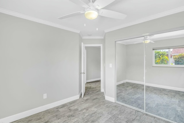 unfurnished bedroom with crown molding, light wood finished floors, a closet, a ceiling fan, and baseboards