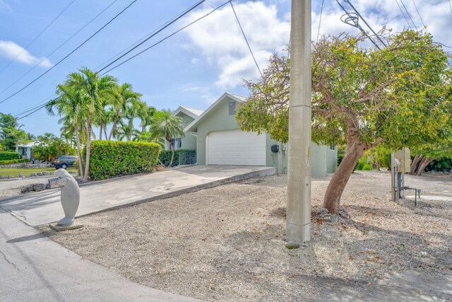 obstructed view of property with a garage, driveway, and stucco siding