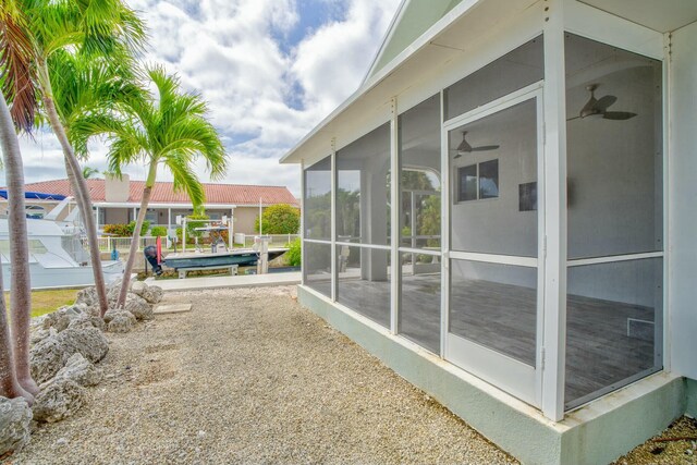 view of yard featuring a ceiling fan and a sunroom