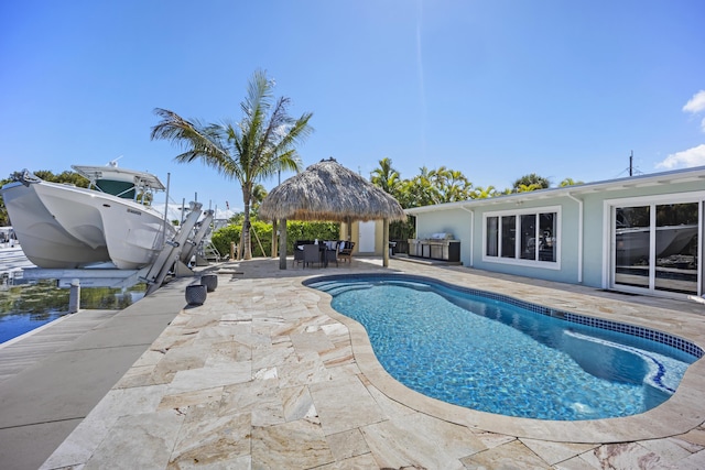 view of swimming pool featuring a gazebo, a boat dock, and a patio