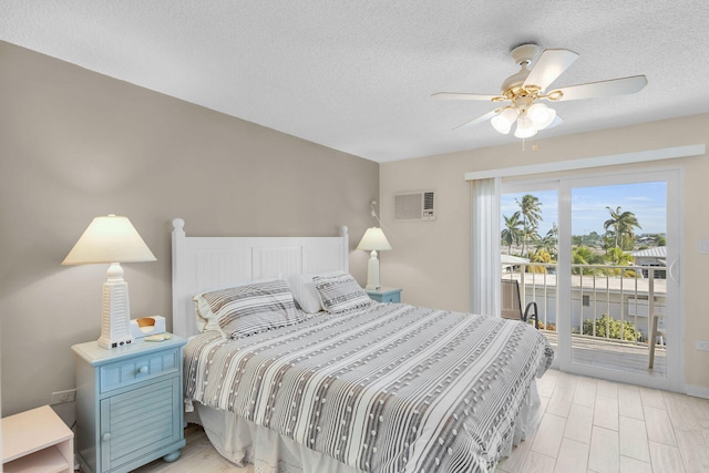 bedroom with a wall mounted AC, a textured ceiling, access to outside, ceiling fan, and light hardwood / wood-style floors