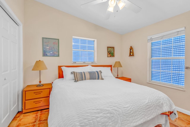 tiled bedroom with lofted ceiling, a closet, and ceiling fan