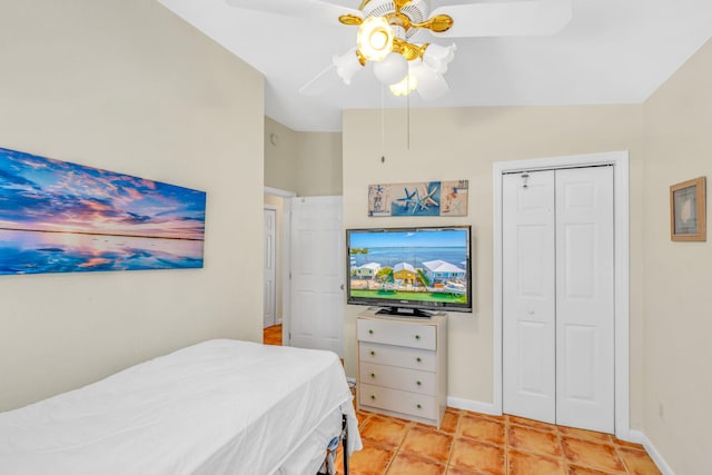 bedroom with light tile patterned floors, vaulted ceiling, a closet, and ceiling fan