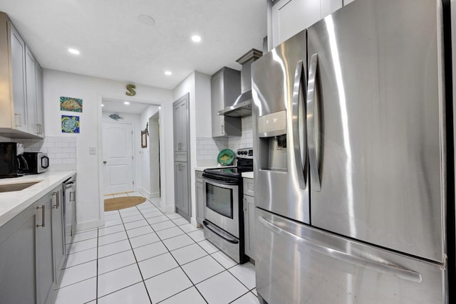 kitchen with gray cabinetry, light tile patterned floors, tasteful backsplash, and appliances with stainless steel finishes