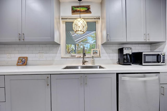 kitchen with sink, decorative light fixtures, decorative backsplash, and appliances with stainless steel finishes