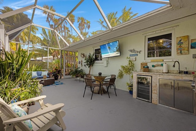 view of patio / terrace with wine cooler, sink, area for grilling, glass enclosure, and an outdoor living space