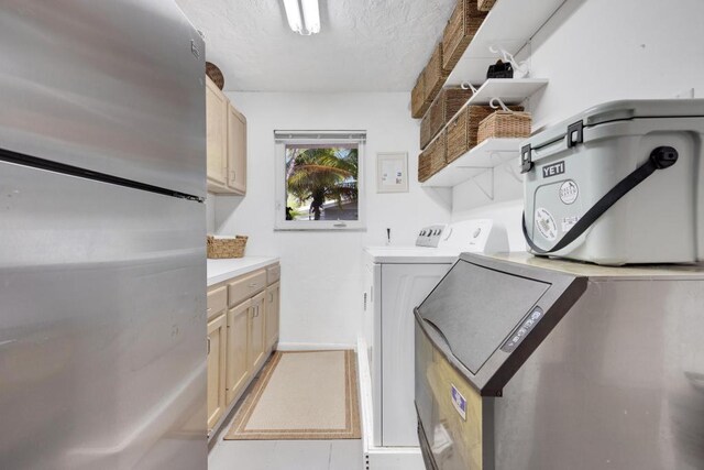 laundry area featuring washer and clothes dryer, cabinets, and a textured ceiling