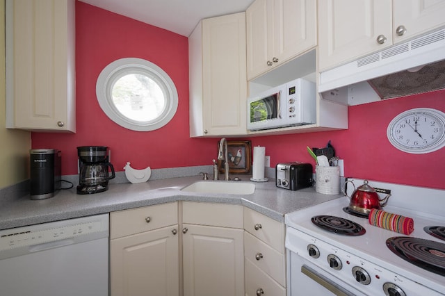 kitchen featuring under cabinet range hood, light countertops, white cabinets, white appliances, and a sink