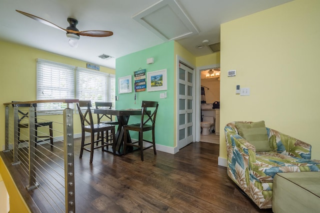 dining space with visible vents, a ceiling fan, wood finished floors, baseboards, and attic access