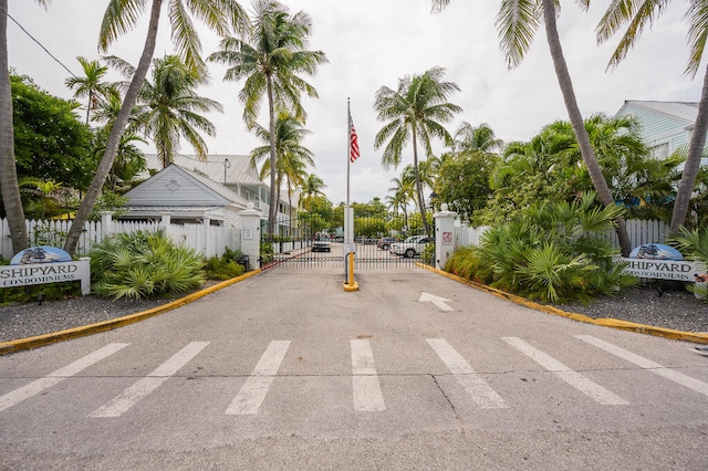 view of road with curbs, a gated entry, and a gate