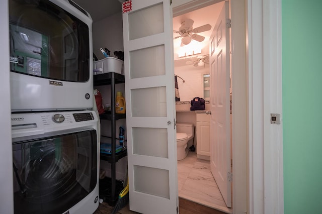 washroom with marble finish floor, ceiling fan, laundry area, and stacked washing maching and dryer