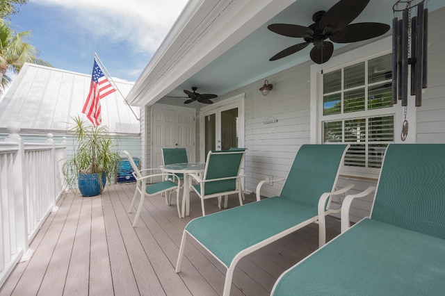 wooden terrace featuring outdoor dining area and a ceiling fan