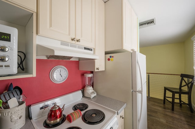 kitchen featuring visible vents, dark wood-type flooring, under cabinet range hood, light countertops, and white appliances