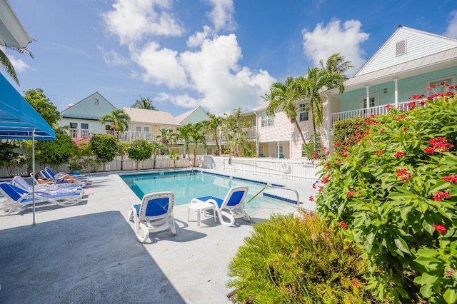 pool featuring a residential view, a patio, and fence