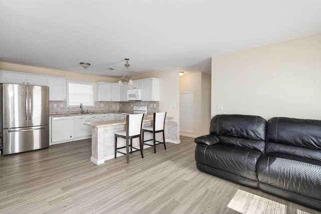 living room with sink and light wood-type flooring