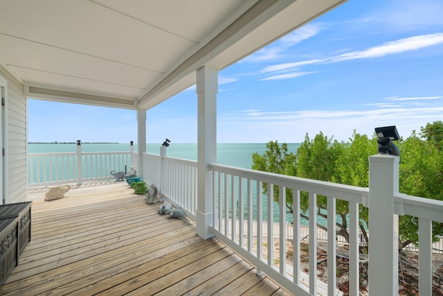 wooden terrace with a water view and a view of the beach