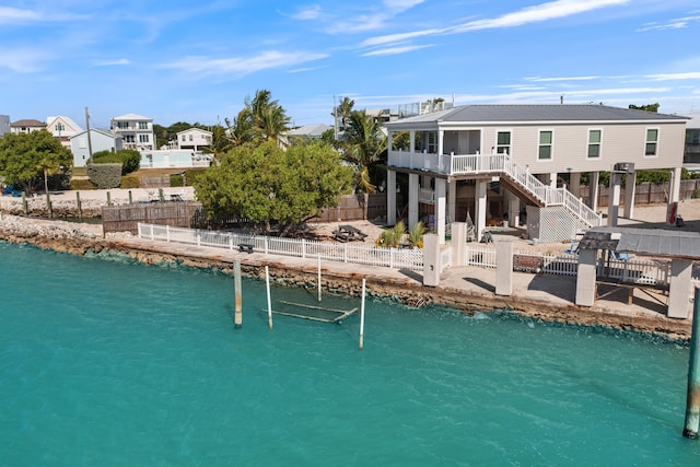 back of property featuring a deck with water view and a patio area