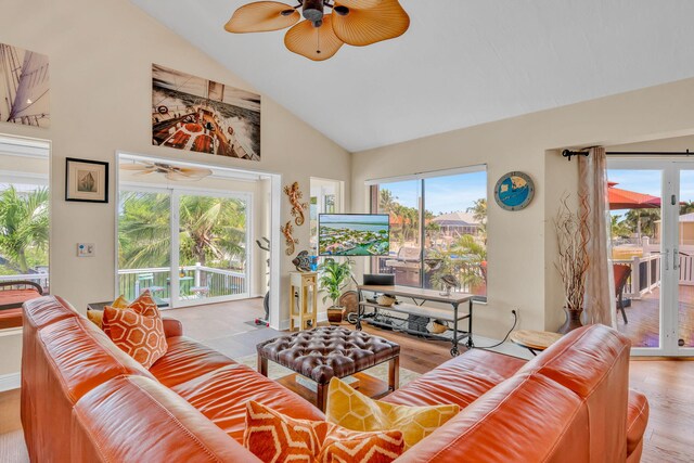 living room with ceiling fan, high vaulted ceiling, and light hardwood / wood-style floors