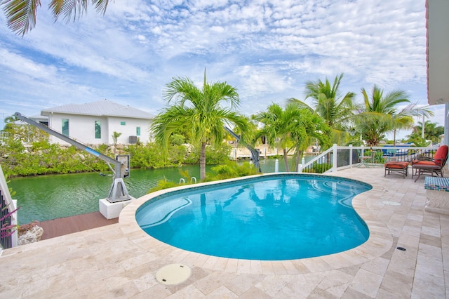 view of pool featuring a patio and a water view