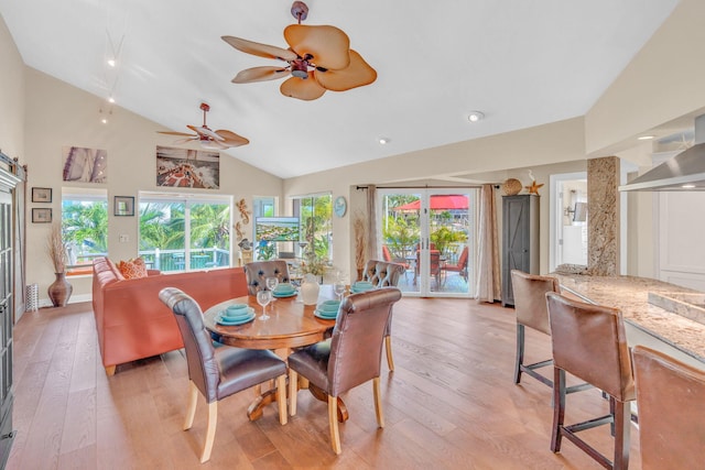 dining room with ceiling fan, lofted ceiling, and light hardwood / wood-style floors