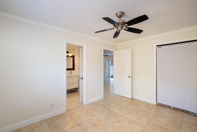 unfurnished bedroom featuring ornamental molding, light tile patterned floors, ceiling fan, ensuite bath, and a closet