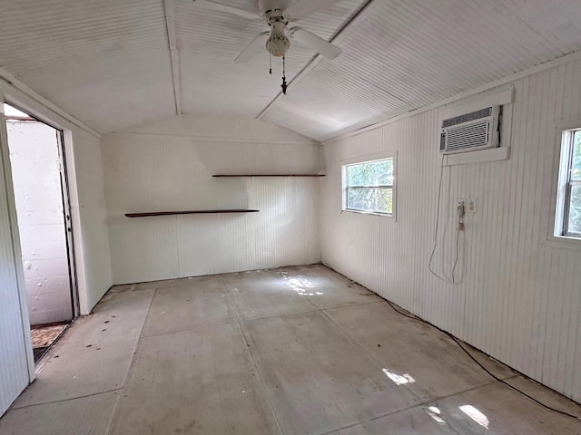 empty room with vaulted ceiling, a wall unit AC, and ceiling fan