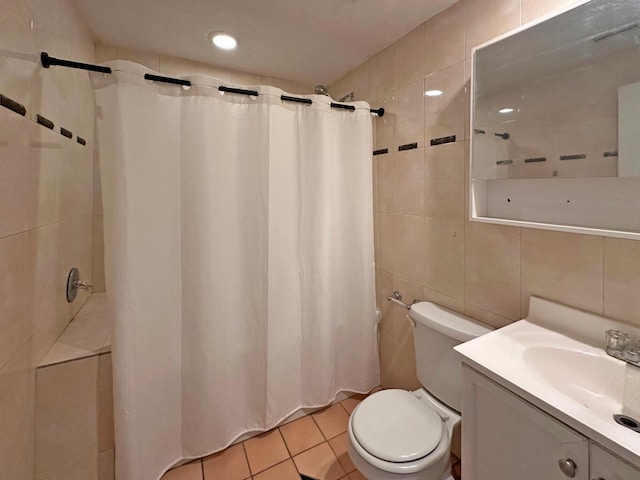 bathroom featuring tile patterned floors, toilet, tile walls, vanity, and decorative backsplash