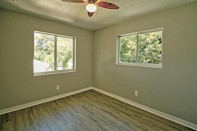 spare room with ceiling fan, plenty of natural light, dark hardwood / wood-style flooring, and a textured ceiling