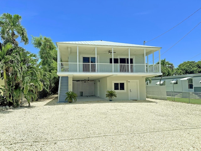 rear view of house with ceiling fan and a carport